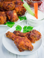 Roasted chicken served with celery and carrot sticks, blue cheese dressing and hot sauce