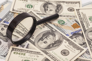Hundred dollar banknotes under magnifying glass
