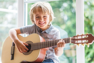 Naklejka premium Boy playing acoustic guitar
