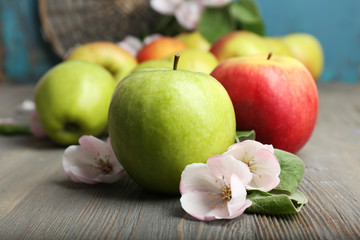 Fresh apples with apple blossom on wooden table