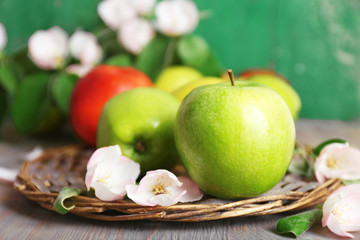 Fresh apples with apple blossom on wooden table