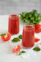Tomato juice and fresh tomatoes on wooden table close-up