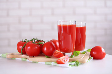 Tomato juice and fresh tomatoes on wooden table close-up