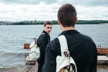 two young guys standing on a pier