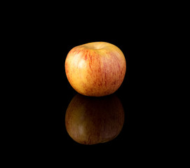 An apple on a black mirror surface