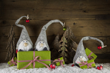 Dekoration zu Weihnachten auf Holz Hintergrund mit Schnee, Geschenke und Wichtelmänner.