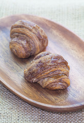 Mini chocolate croissant in wood plate on wood table