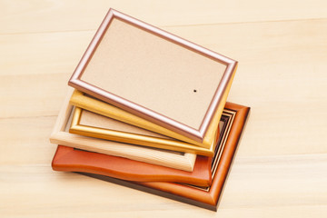 Stack of picture frames isolated on a wooden background