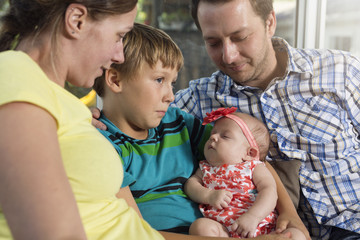 Portrait of a young happy family with the kid at home