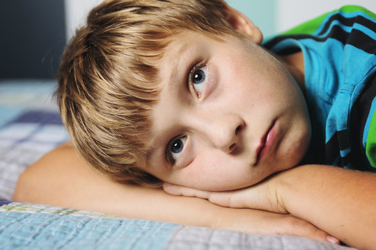 Portrait of a thinking boy on a bed