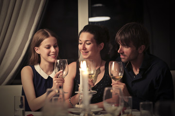 Three friends sitting together drinking wine
