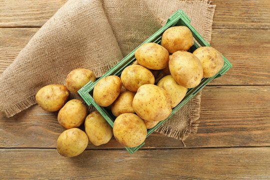 Young potatoes in crate on table close up