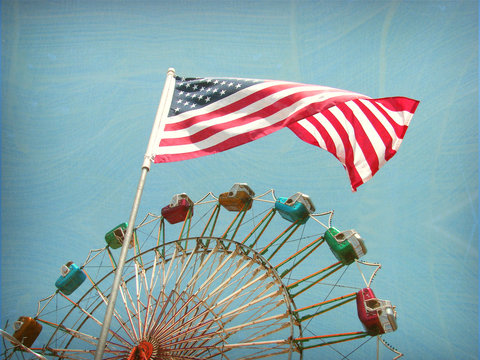aged and worn vintage photo of american flag and ferris wheel