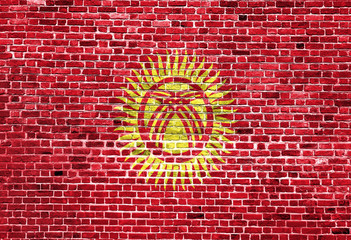 Flag of Kyrgyzstan painted on brick wall, background texture