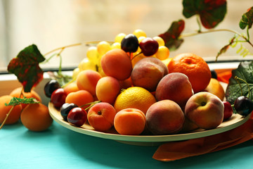 Heap of fresh fruits on windowsill