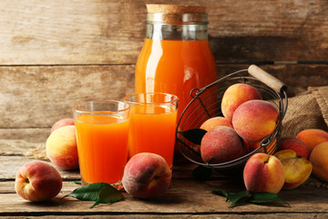 Ripe peaches and juice on wooden background