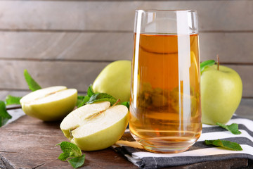 Glass of apple juice on wooden background
