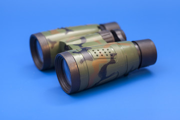 Binoculars on blue background