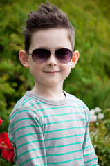 Eyewear concept. Stylish baby boy with dark hair in trendy sungl