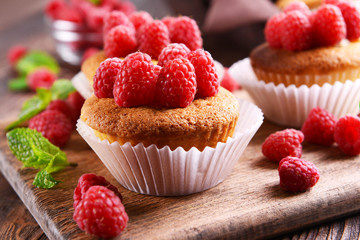 Delicious cupcakes with berries and fresh mint on wooden table close up