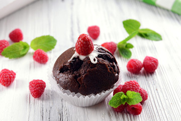 Delicious chocolate cupcake with berries on wooden table close up