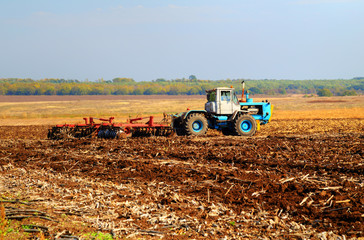 Farmer in tractor preparing land for sowing