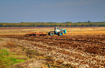 Fototapeta premium Farmer in tractor preparing land for sowing