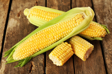 Fresh corn on cobs on rustic wooden table, closeup