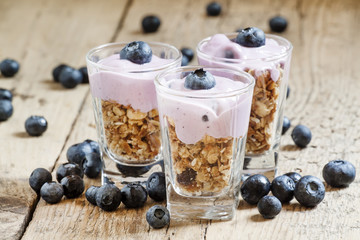 Homemade baked granola with yogurt and blueberries in a glass an