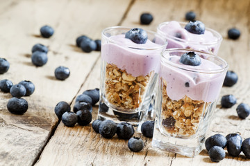 Homemade baked granola with yogurt and blueberries in a glass an