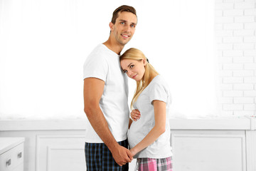 Young pregnant woman with husband in room