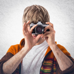 Blonde man photographing over white background