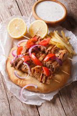 Greek kebab with tomatoes, onions and french fries on pita bread 
