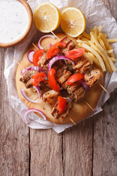 Greek souvlaki with vegetables and french fries. vertical top view
