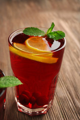Glass of cherry juice on wooden background