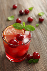 Glass of cherry juice on wooden table, closeup