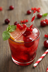 Glass of berry juice on wooden table, closeup