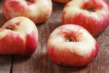 Flat pink nectarine on an old wooden background, selective focus