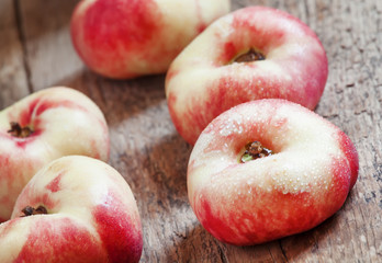 Flat pink nectarine on an old wooden background, selective focus