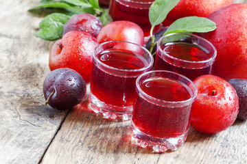 Delicious fresh juice of red and blue sweet plums in a glass on