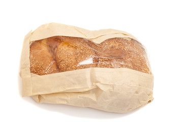 White bread with sesame in a paper bag isolated on white backgro