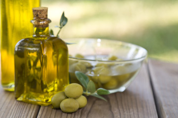olive oil and olives on wooden background