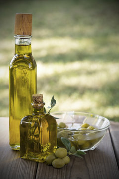 olive oil and olives on wooden background