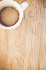 hot chocolate in a white porcelain cup on a natural wood background