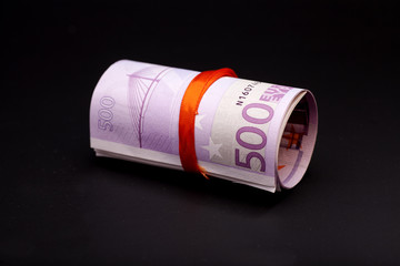 500 euro money in  red ribbon on black