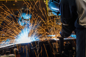 Team worker with protective mask welding.
