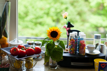 Fototapeta na wymiar window board - Fensterbrett mit Sonnenblume und Tomaten