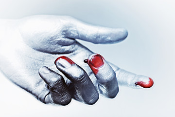 male hand in silver paint with drops of blood