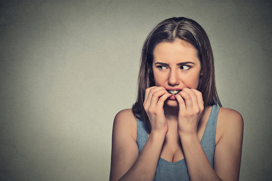 unsure hesitant nervous woman biting her fingernails