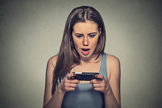 anxious shocked young girl looking at phone seeing bad news or photos